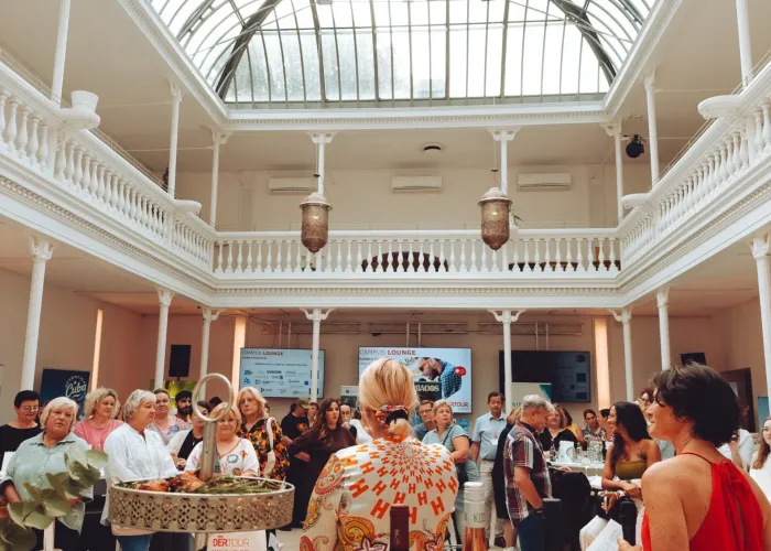 Feier im Palmenhaus Erfurt: Gäste im Erdgeschoss, darüber die zweigeschossige Galerie und das Glasdach.