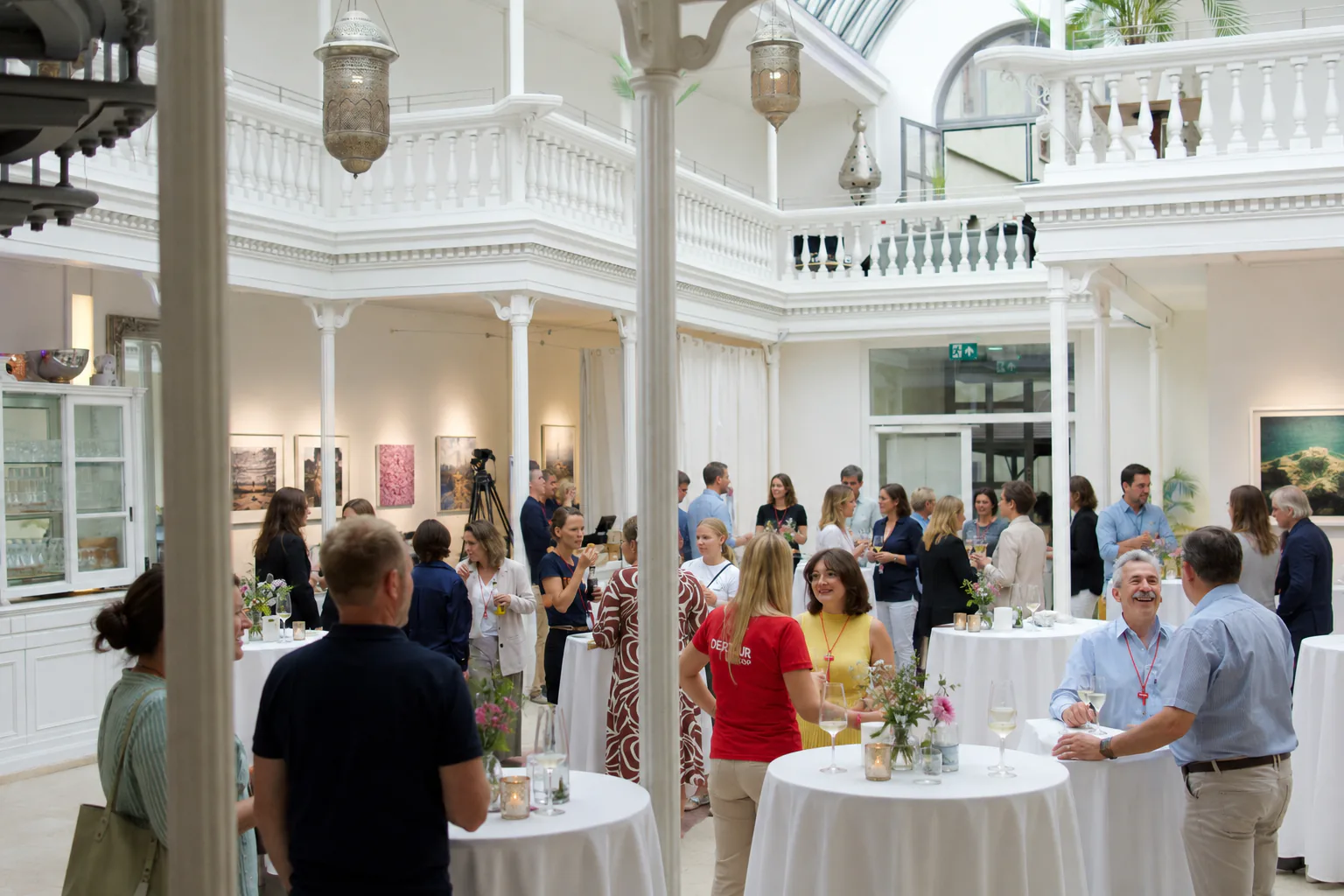 Stehempfang im Palmenhaus Erfurt: Gäste an Bistrotischen unter dem Glasdach.